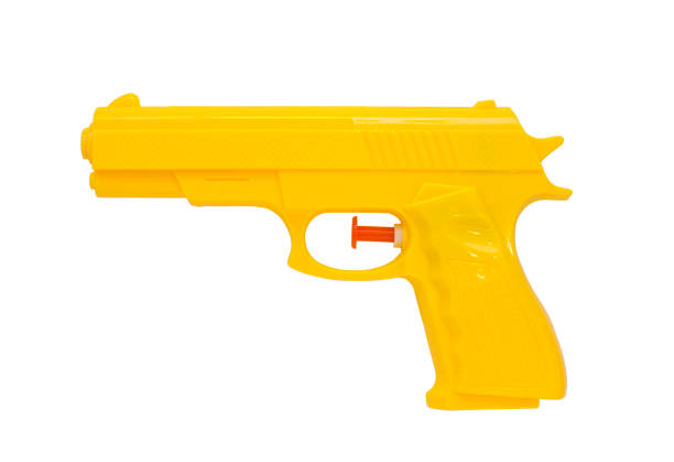 pistola plástica de aerosol, fondo amarillo, blanco - toy gun fotografías e imágenes de stock