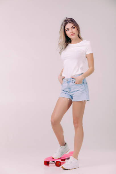 beautiful woman in white t-shirt with pink skateboard - shirt women pink jeans imagens e fotografias de stock