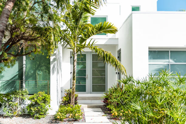 architecture d'entrée moderne de luxe de la maison dans l'île de ville de floride sur le voyage, jour ensoleillé, propriété immobilière avec la décoration de jardin d'aménagement paysager, fenêtres en verre vertes - lawn residential district landscaped community photos et images de collection