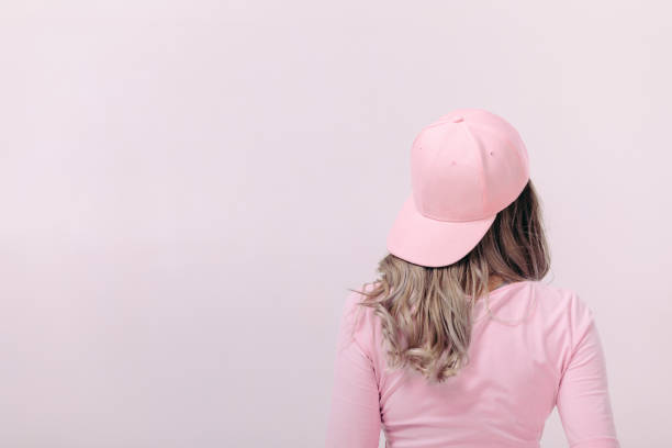 beautiful woman in white t-shirt with pink skateboard blonde woman in pink t-shirt and pink cap on light background. femininity and spring. copy space. woman wearing baseball cap stock pictures, royalty-free photos & images