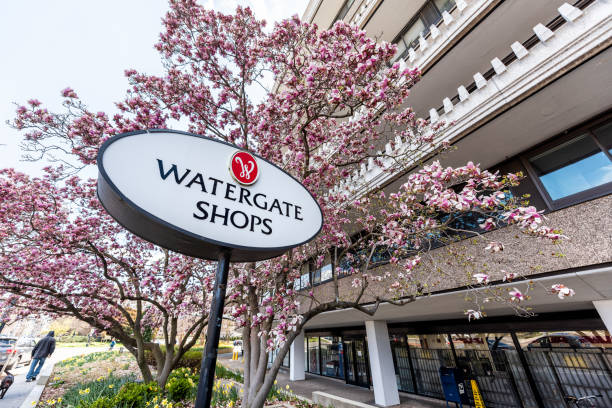 Watergate Shops hotel sign building in capital city, residential building closeup with pink magnolia blossom flowers in spring Washington DC, USA - April 5, 2018: Watergate Shops hotel sign building in capital city, residential building closeup with pink magnolia blossom flowers in spring hotel watergate stock pictures, royalty-free photos & images