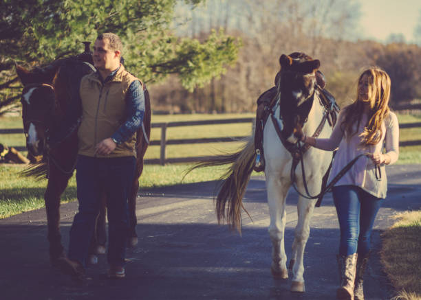 istock Couple walking with horses 1131402837