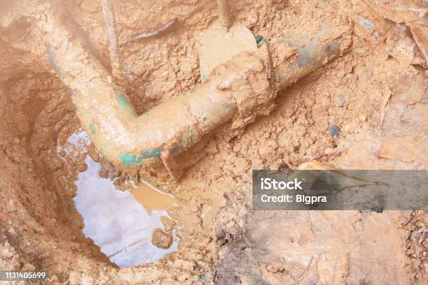 Broken Pipe In Hole With Water Motion At Roadside Wait Repair Stock Photo - Download Image Now