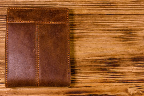 istock Closed brown leather wallet on wooden table. Top view 1131405746