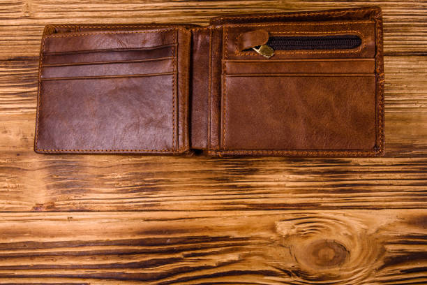 istock Opened brown leather wallet on wooden table. Top view 1131405761