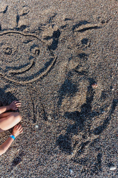 istock Top view of a child drawing smiley face in a sand 1131406092