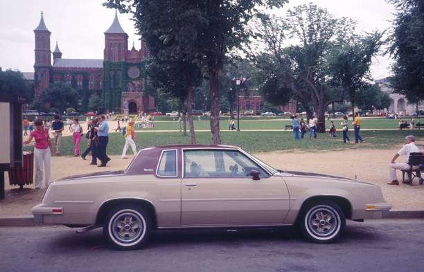 National Mall , Washington DC, USA, 1980. Street scene in front of the Smithsonian Castle with pedestrians, students, a parked car, seniors and families .
