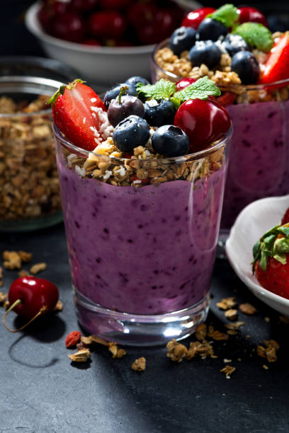 istock healthy blueberry with granola and berries on a dark background, vertical 1131408543