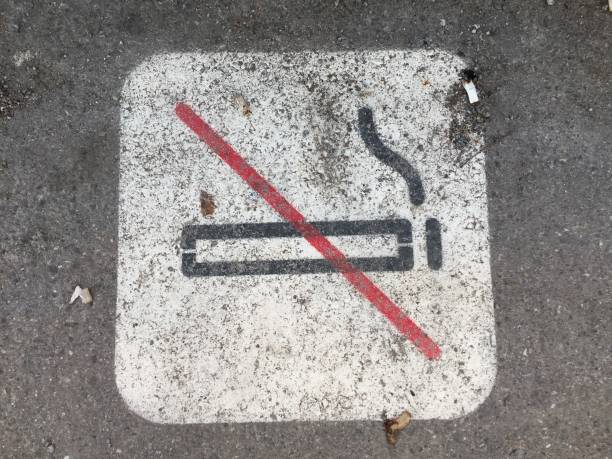 istock Non Smoking sign on pavement with cigarette butts around it 1131409551