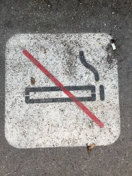 istock Non Smoking sign on pavement with cigarette butts around it 1131409554