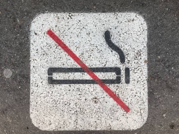 istock Non Smoking sign on pavement with cigarette butts around it 1131409564