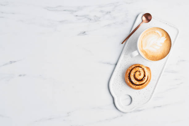 istock Freshly baked cinnamon roll and coffee with latte art 1131410383