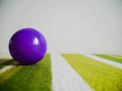 Purple plastic balls on green carpet