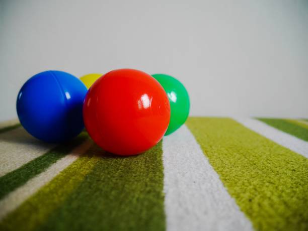 istock Group of multi colored plastic ball on green carpet 1131410590