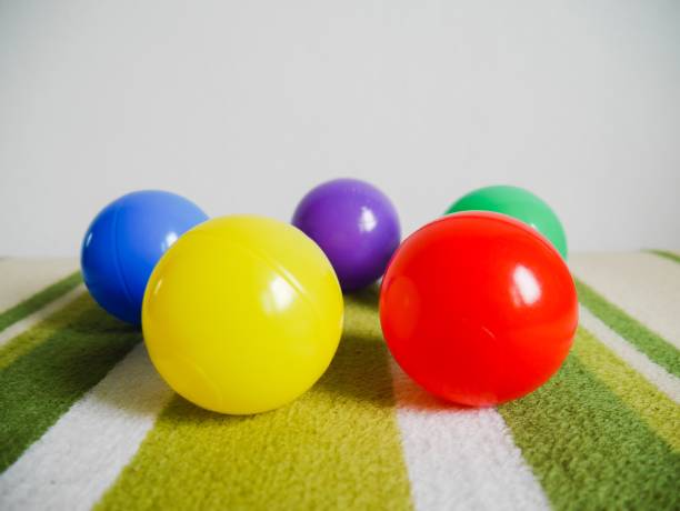 istock Group of multi colored plastic ball on green carpet 1131410595