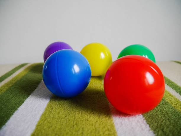 istock Group of multi colored plastic ball on green carpet 1131410600