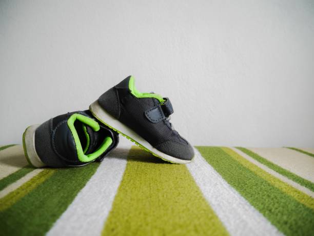 istock Kid shoe on green carpet 1131410881