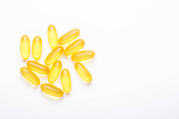 Omega 3 capsules on white background Fish oil Yellow softgels Vitamin D, E, A supplement Concept of healthcare