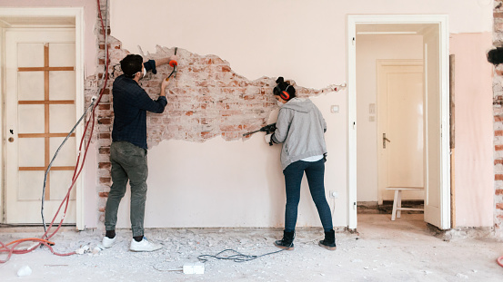 Young couple working on reconstruction of their apartment