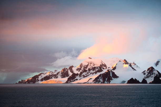 iceberg al tramonto sul bellissimo mare - uncultivated snow ice antarctica foto e immagini stock