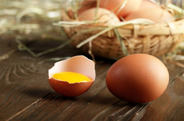 istock Broken egg with yolk and fresh brown organic eggs on wooden table 1131420515