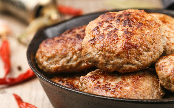 homemade juicy fried meat cutlets (beef, pork, chicken, turkey) with spices and garlic in a cast iron pan. delicious lunch or dinner. selective focus - turkey burger imagens e fotografias de stock