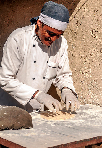 JERASH, JORDAN-FEBRUARY 2015. Arab man making the dough from a pizza outdoors in the desert. It´s a traction for the tourist near the majestic city of Petra.