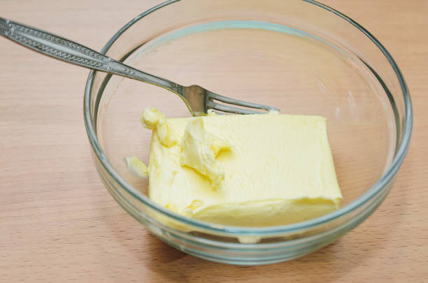 softened butter in a glass dish, cooking home-made cake - margarine dairy product butter close up imagens e fotografias de stock