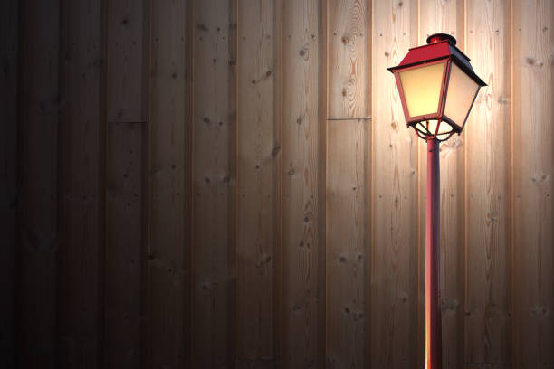 Illuminated floor lamp in front of a wood paneled facade
