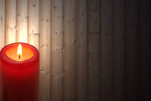 Burning candle illuminating a wood paneled facade