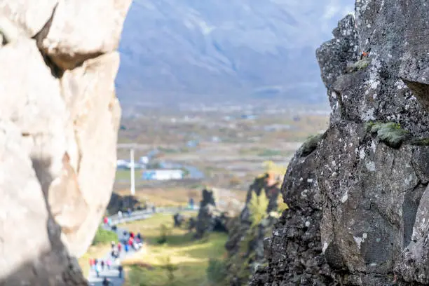 Photo of Thingvellir, Iceland National Park canyon continental divide plate closeup during day landscape people on trail below bokeh