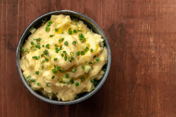 istock Pomme puree, mashed potatoes with scallions and thyme, shot from the top on a dark rustic background with a place for text 1131428005