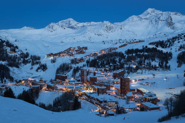 View of high altitude ski resorts in French Savoy Alps in twilight: Plagne Centre, Plagne Soleil and Plagne Village View of high altitude ski resorts in French Savoy Alps in twilight: Plagne Centre, Plagne Soleil and Plagne Village  are parts of the world's second largest linked ski area called Paradiski la plagne photos stock pictures, royalty-free photos & images