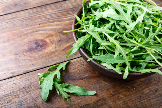 istock fresh arugula salad in a clay plate on the table. 1131434375