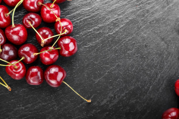 istock ripe red sweet cherries on a black background. 1131434819