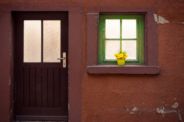 窓辺の花瓶に春の花と緑の木製の窓を通って来る日光 - building exterior built structure old house ストックフォトと画像