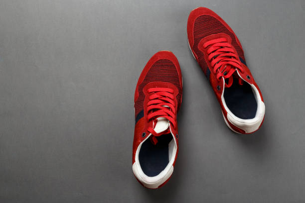 istock men's new red sneakers on a black background. 1131435864
