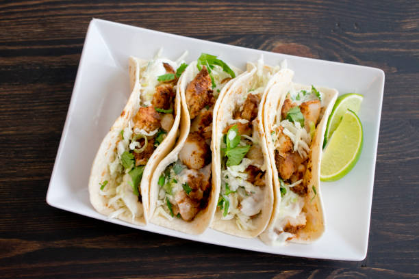 Fish Tacos with Lime Crema A plate of fish tacos topped with lime crema tacos stock pictures, royalty-free photos & images