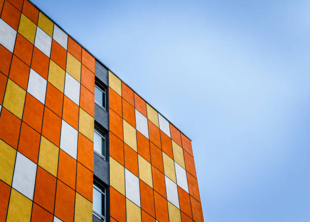 istock A modern colored orange tall building against a blue gloomy sky. 1131438346