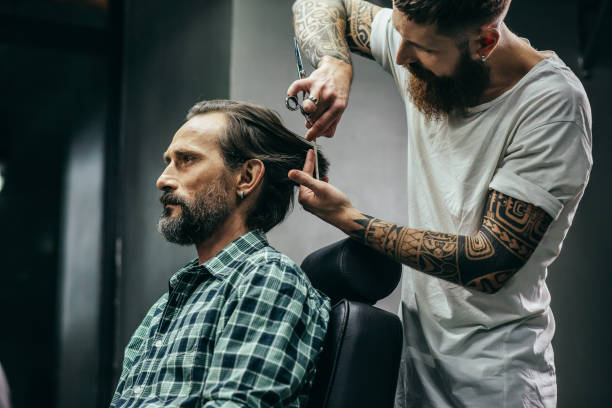 istock Barbershop visitor looking calm while barber cutting his hair 1131439644