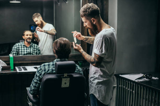 istock Cheerful man smiling and the barber combing his hair 1131440524