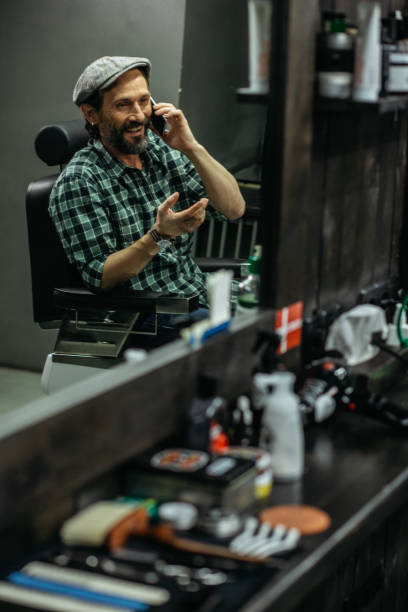istock Emotional man smiling and talking on the phone while being in barber shop 1131443530