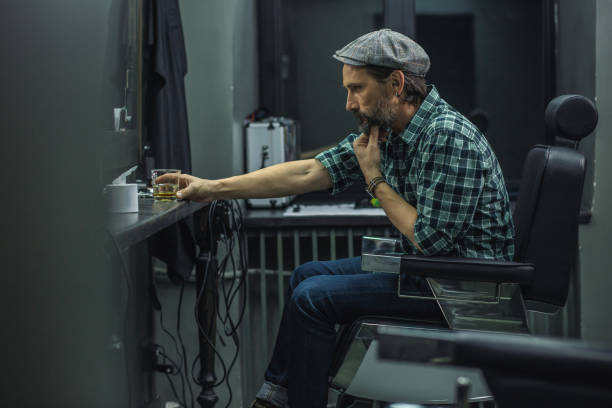 istock Serious man putting glass of alcohol on the table and thinking 1131444836
