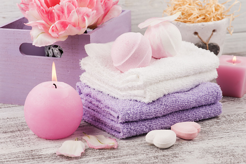 Lavender foaming bath bombs and soaps, spa concept with towels and tulips