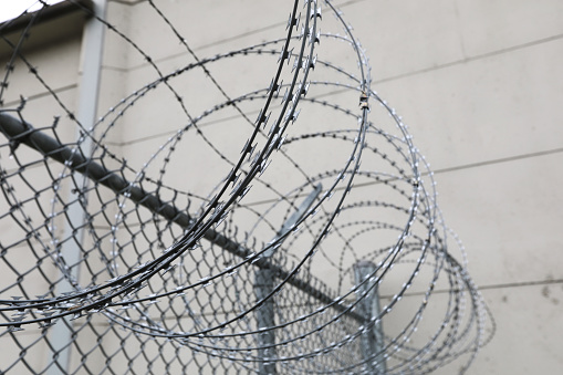Barb wire fence at a correctional services facility in Kingston, Ontario, Canada. Life behind bars. Correctional facility in Canada.