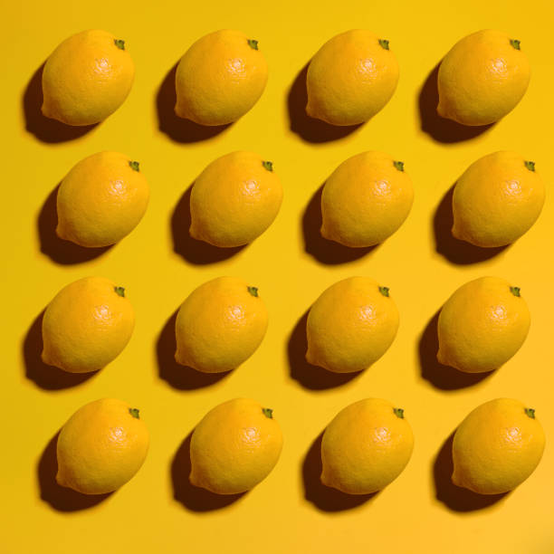 istock Colorful yellow lemons on a yellow background 1131447377