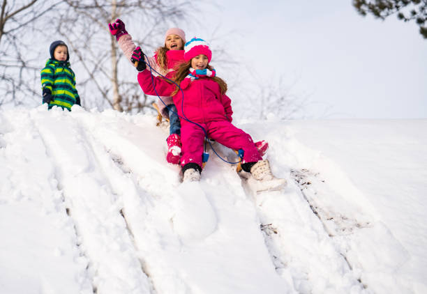 istock Sisters enjoying sliding at snow 1131447766