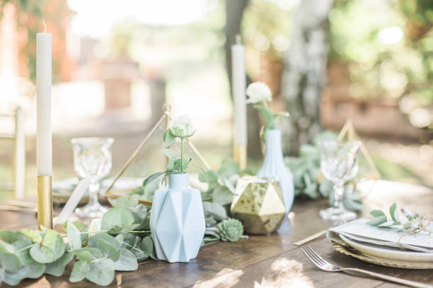 istock Luxury wedding reception dining table setup with eucalyptus branches and gold geometric decoration on a rustic wooden table 1131449318
