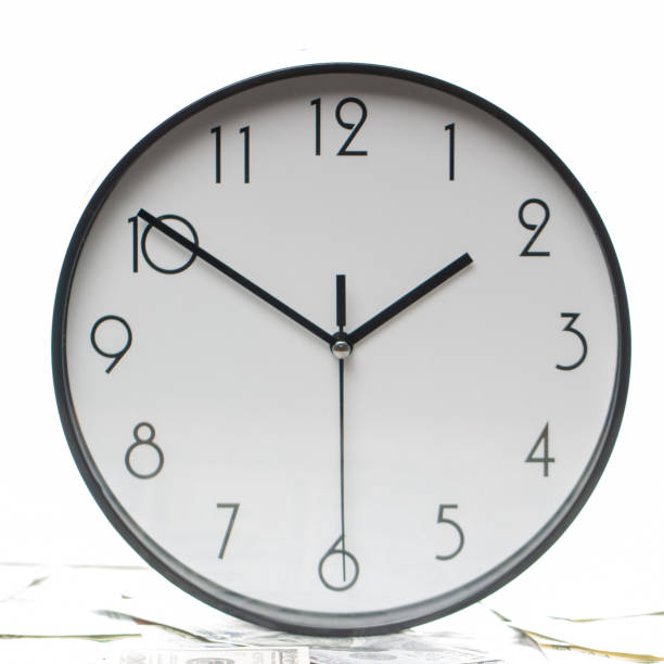 istock One hundred dollar bills and a white big clock, concept, time is money background 1131449426