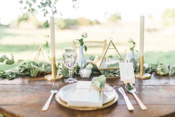 luxe bruiloft receptie eetkamer tafel setup met eucalyptus takken en goud geometrische decoratie op een rustieke houten tafel - andrej stockfoto's en -beelden